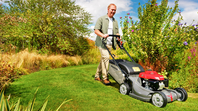 Honda HRX-grasmaaiers, driekwart vooraanzicht, zicht op rechterkant, tuinlocatie.
