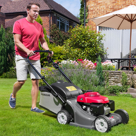 Honda HRX-grasmaaiers, driekwart vooraanzicht, zicht op rechterkant, tuinlocatie.