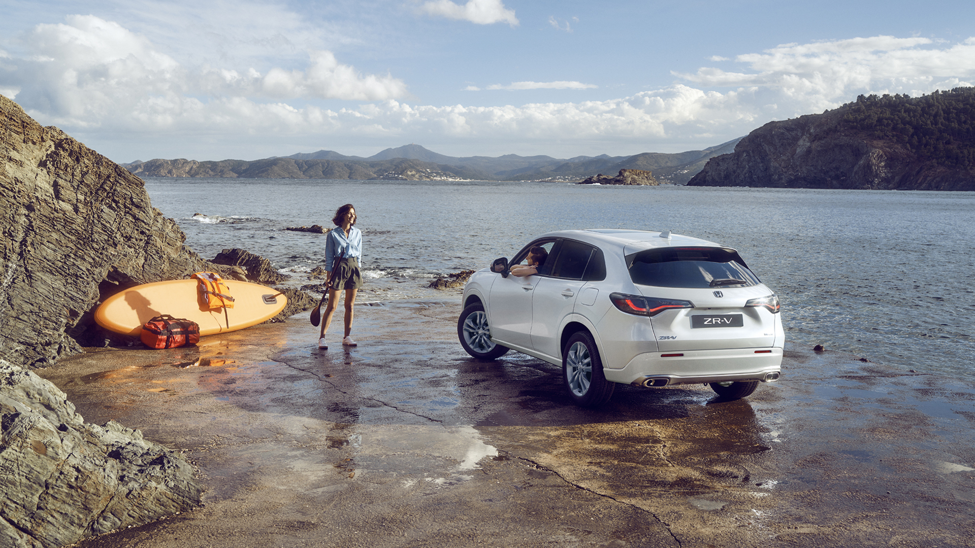 White ZR-V by the coast with woman and canoe