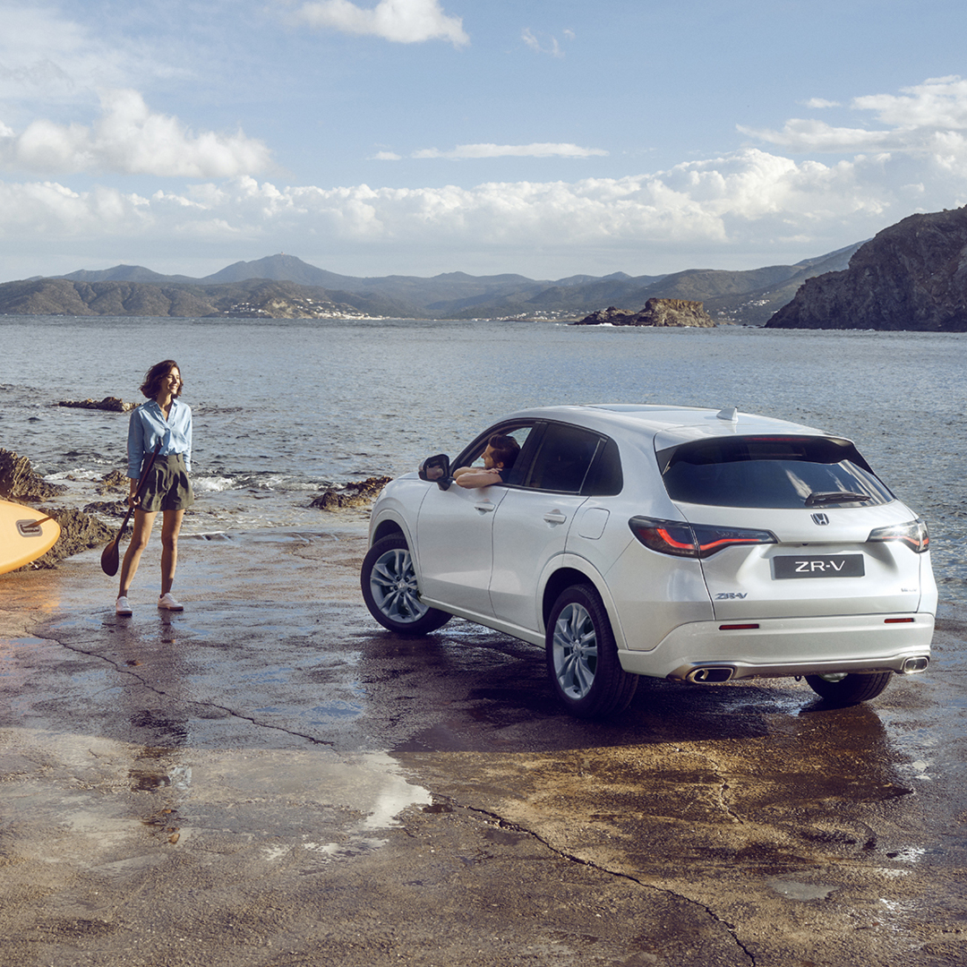 White ZR-V by the coast with woman and canoe