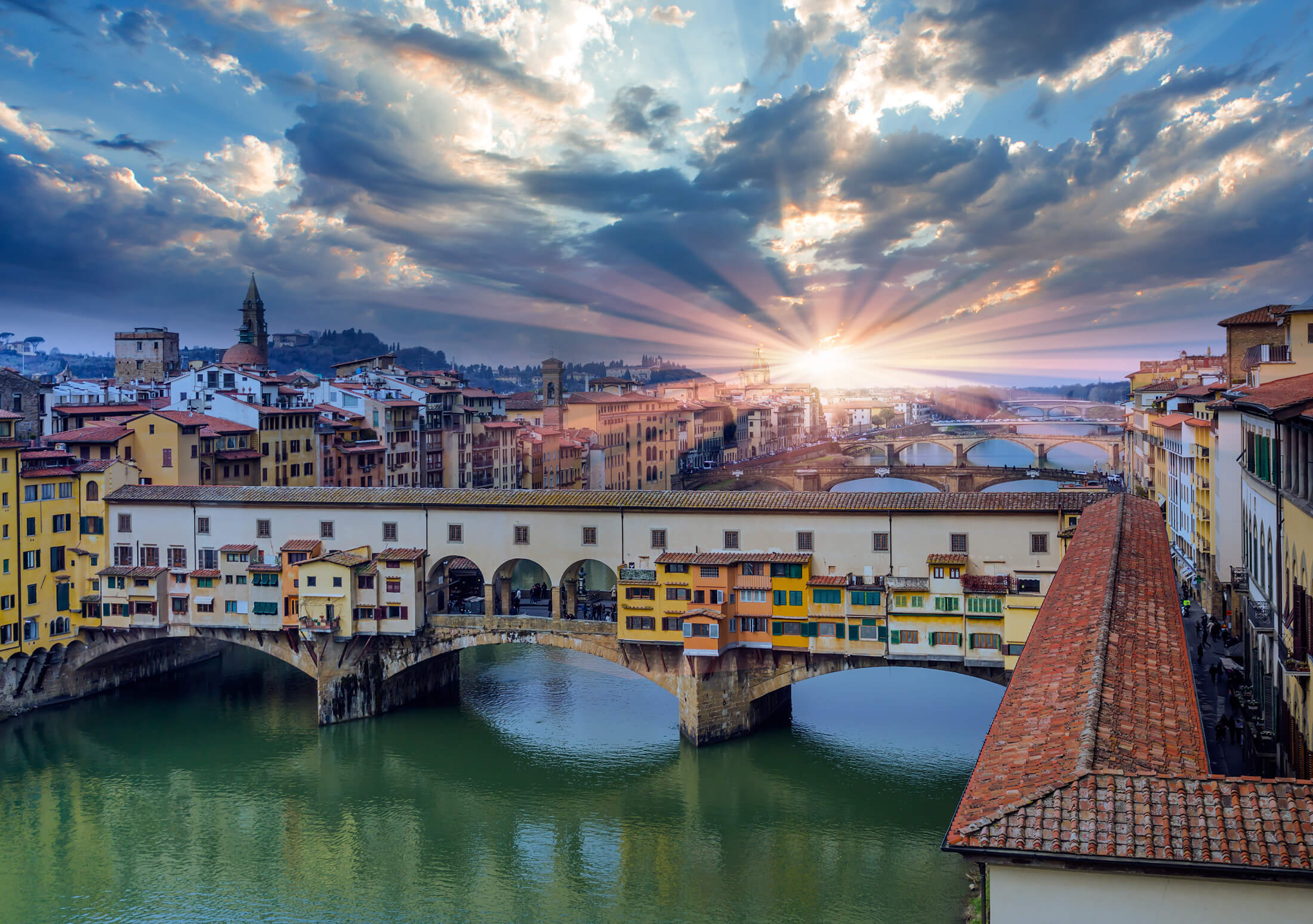 De zon boven Ponte Vecchio in Florence, Italië