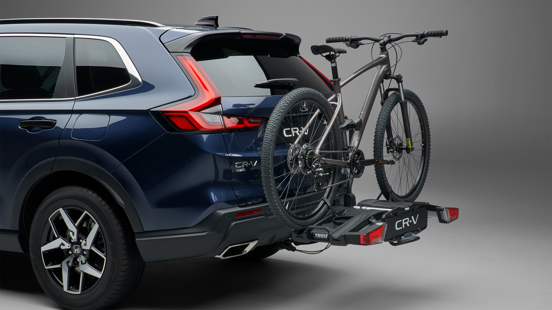 Driekwart naar achteren gerichte Honda CR-V Hybrid met fietsendrager.