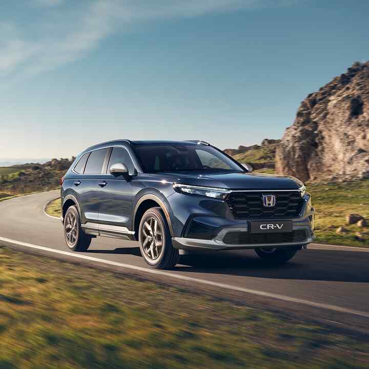 Driekwart vooraanzicht Honda CR-V Hybrid rijdend op berglocatie.