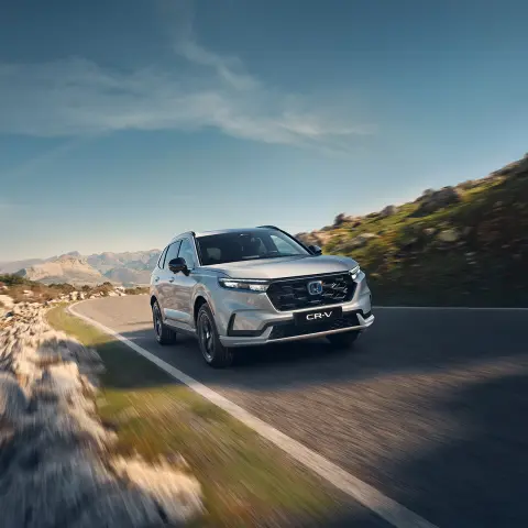 CR-V Hybrid SUV auto rijdt op de weg in een berglocatie.