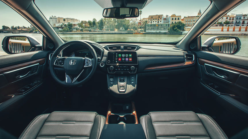Afbeelding van dashboard van Honda CR-V Hybrid op een weidse stadslocatie.