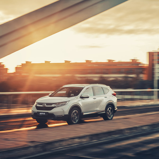 Zijvooraanzicht Honda CR-V Hybrid in stadslocatie.