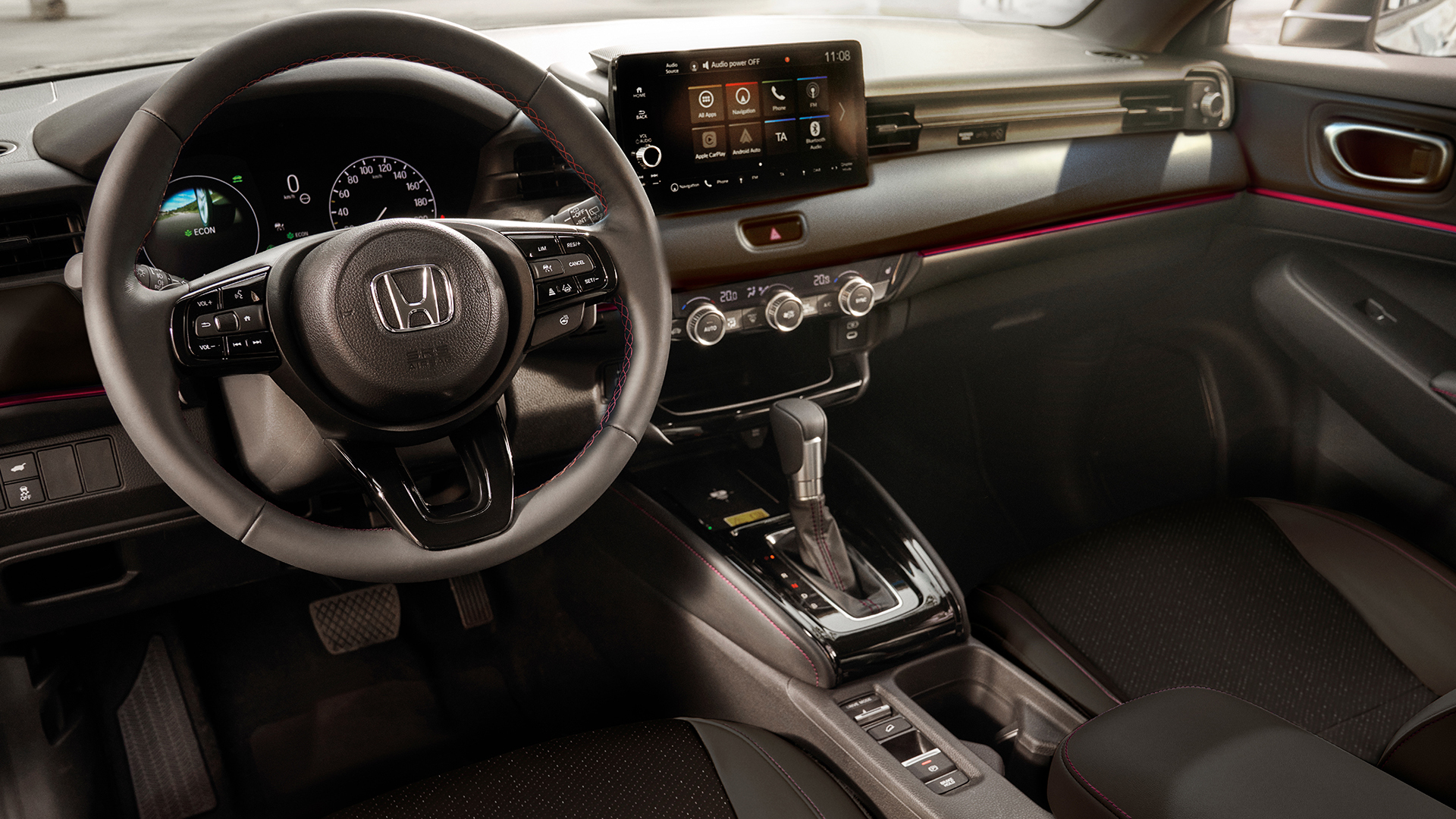 Interior view of a Honda HR-V showing the steering wheel, digital instrument cluster, center touchscreen, and automatic gear selector.
