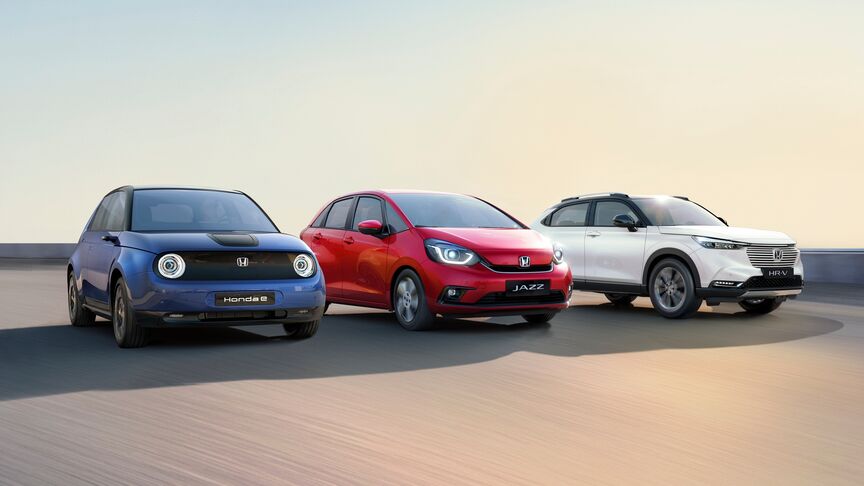Een dame staat naast witte Honda e en gebruikt de My Honda+ app