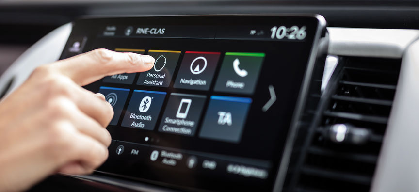 Een man kijkt naar de My Honda+ app met een Honda Jazz Hybrid Crosstar op de achtergrond. 