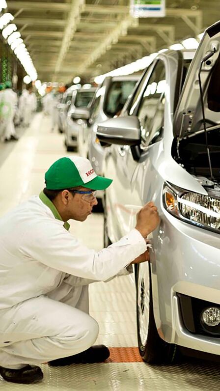 Honda-monteur aan het werk aan een auto in de fabriek.