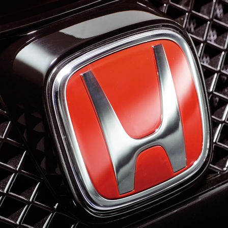 Close-up van het rode 'H'-logo van Honda.