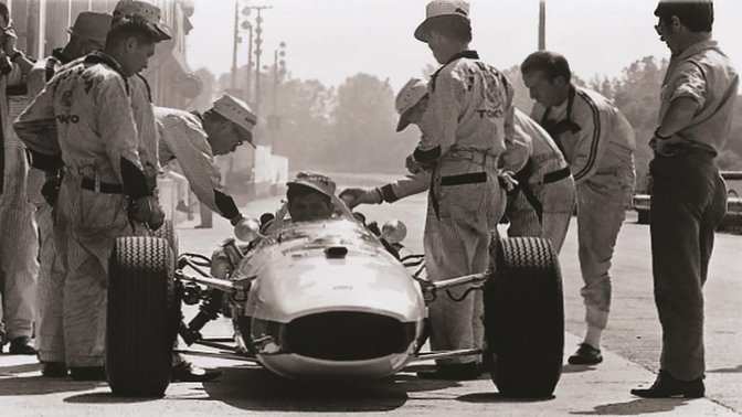 Vooraanzicht van Honda Formule 1-auto uit de jaren zestig met coureur en ontwerpers.