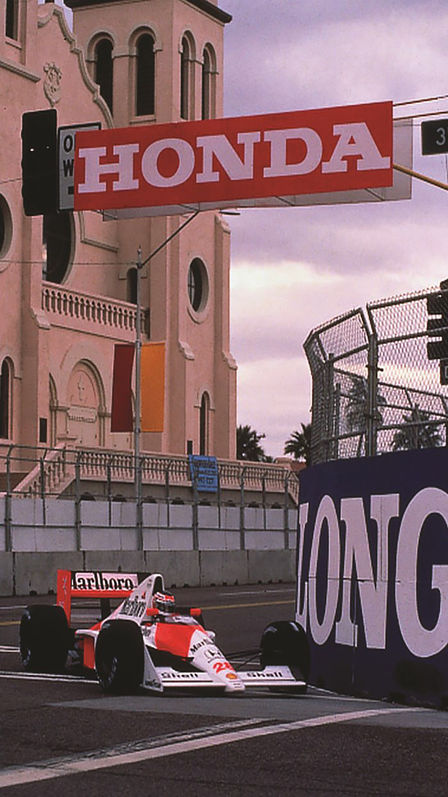 Driekwart vooraanzicht van McLaren Honda Formule 1-auto, racend over het circuit.