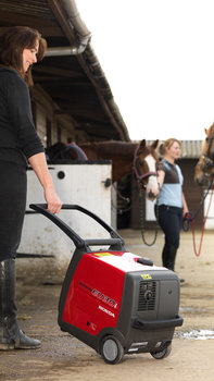 Draagbare generator in gebruik door model, boerderijlocatie.