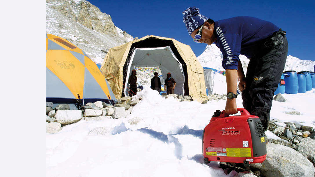 Draagbare generator in gebruik door model, berglocatie.