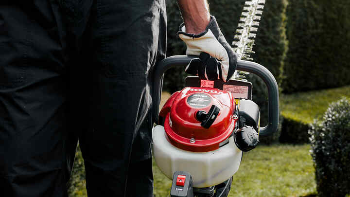 Man houdt heggenschaar vast