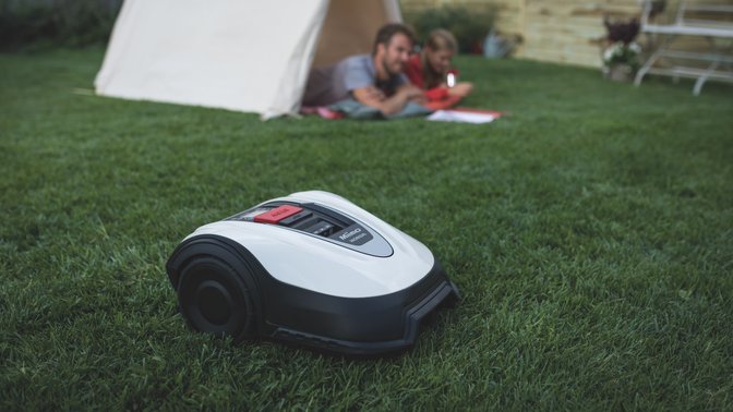 Driekwart aanzicht van Honda Miimo in een tuin met figuranten op de achtergrond.