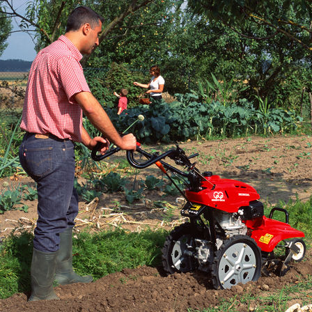 Roterende tuinfrees, in gebruik door model, tuinlocatie.