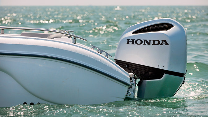 Zijaanzicht van boot met Honda buitenboordmotor.