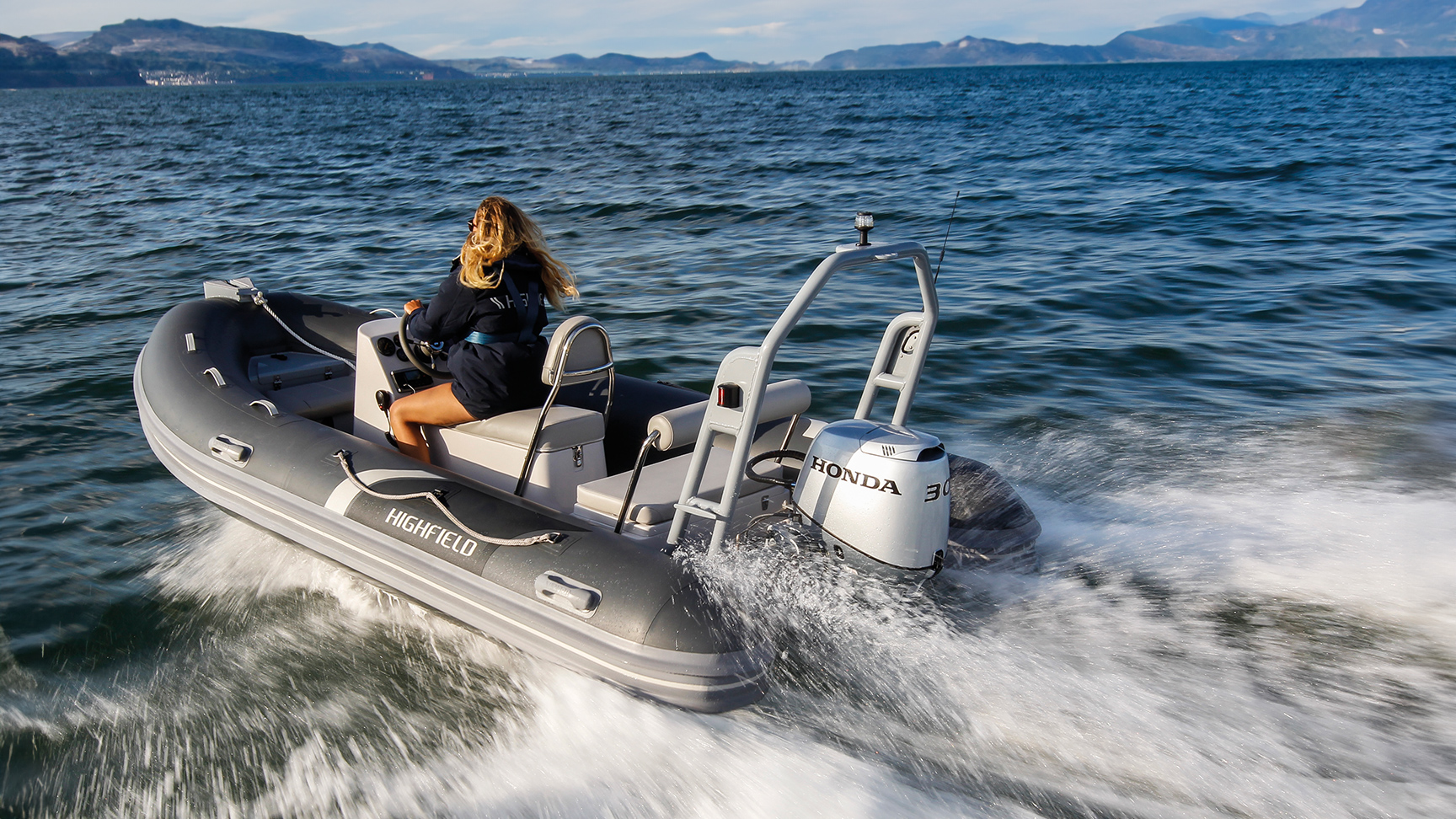 Dame in een highfield boot met een Honda BF30 motor op zee.