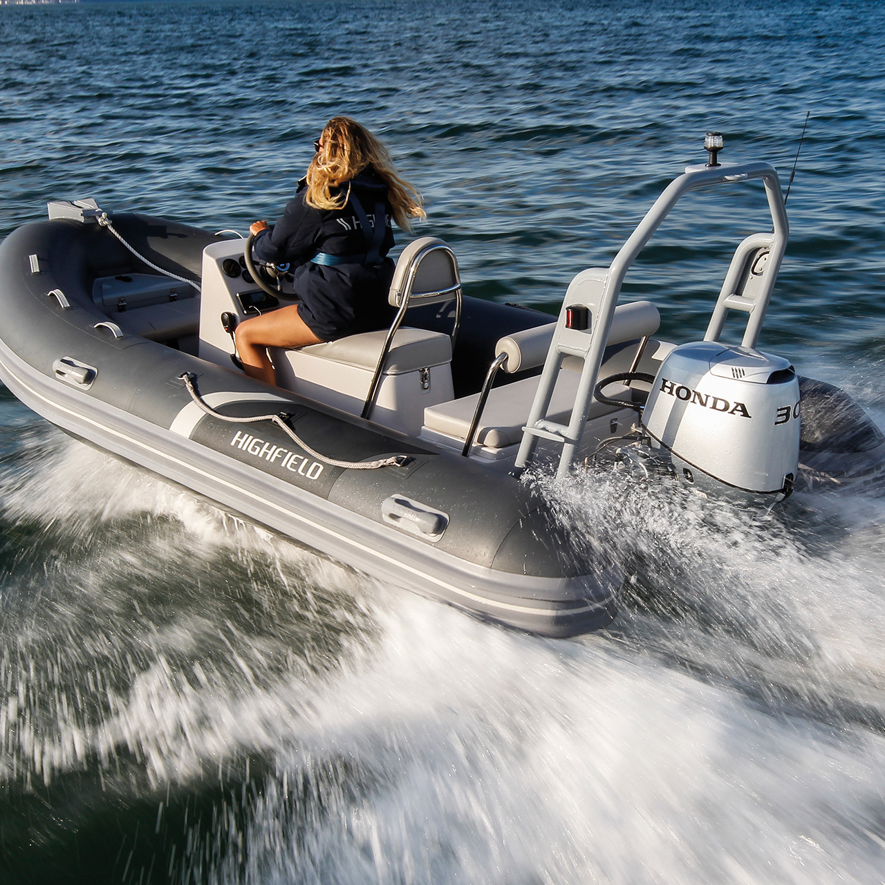 Dame in een highfield boot met een Honda BF30 motor op zee.