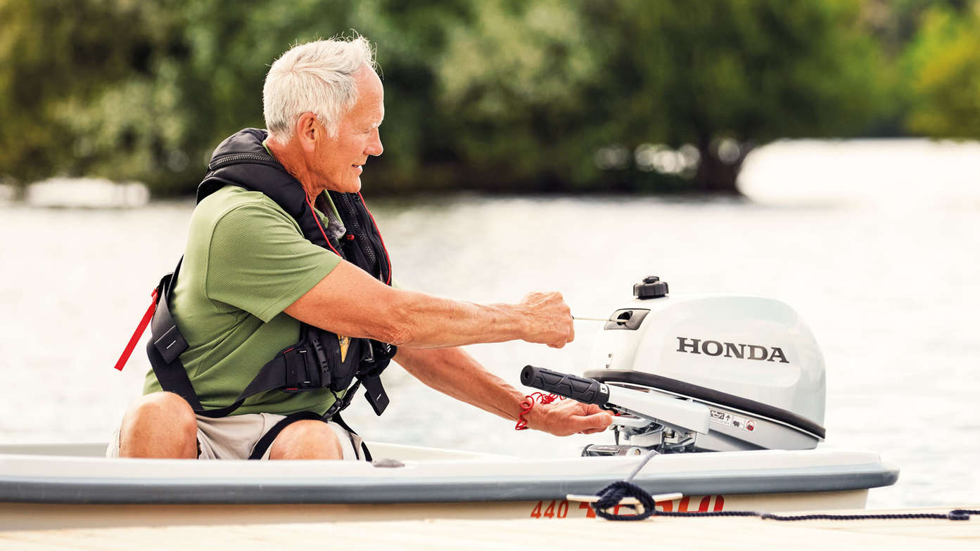 Model op een boot die de motor start.