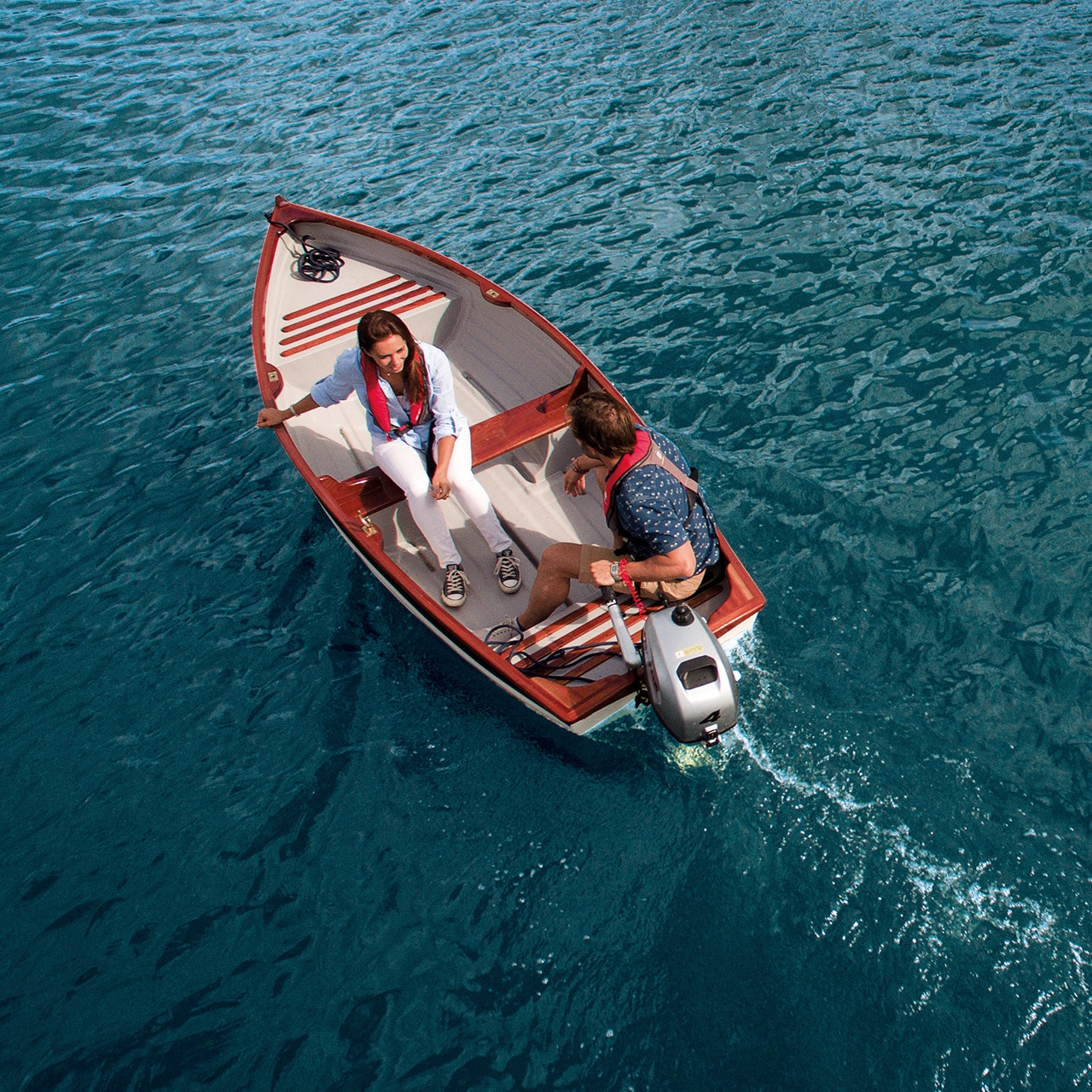 Paar in een boot met Honda-motor op het water.