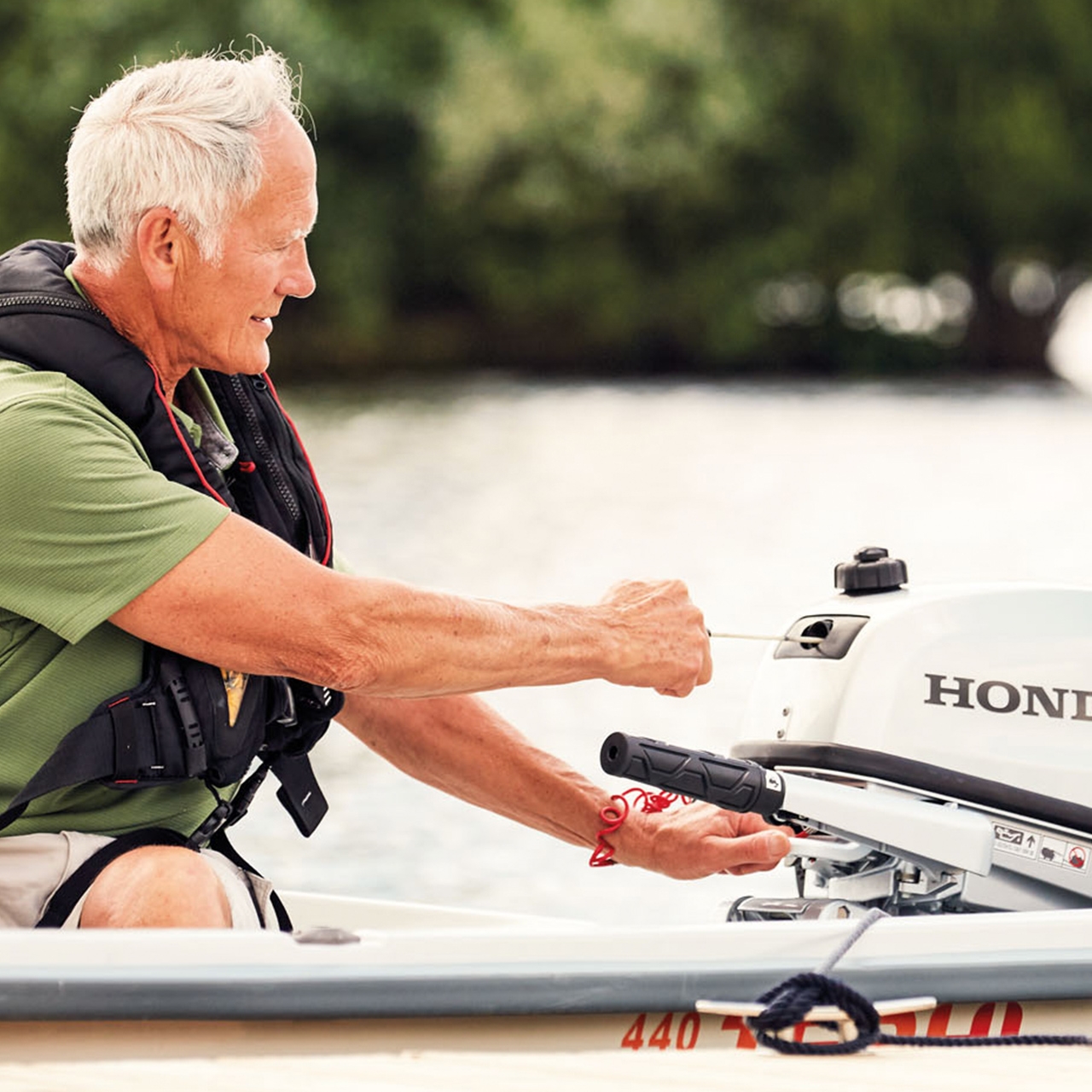 Een man op een boot start een Honda BF5 motor.