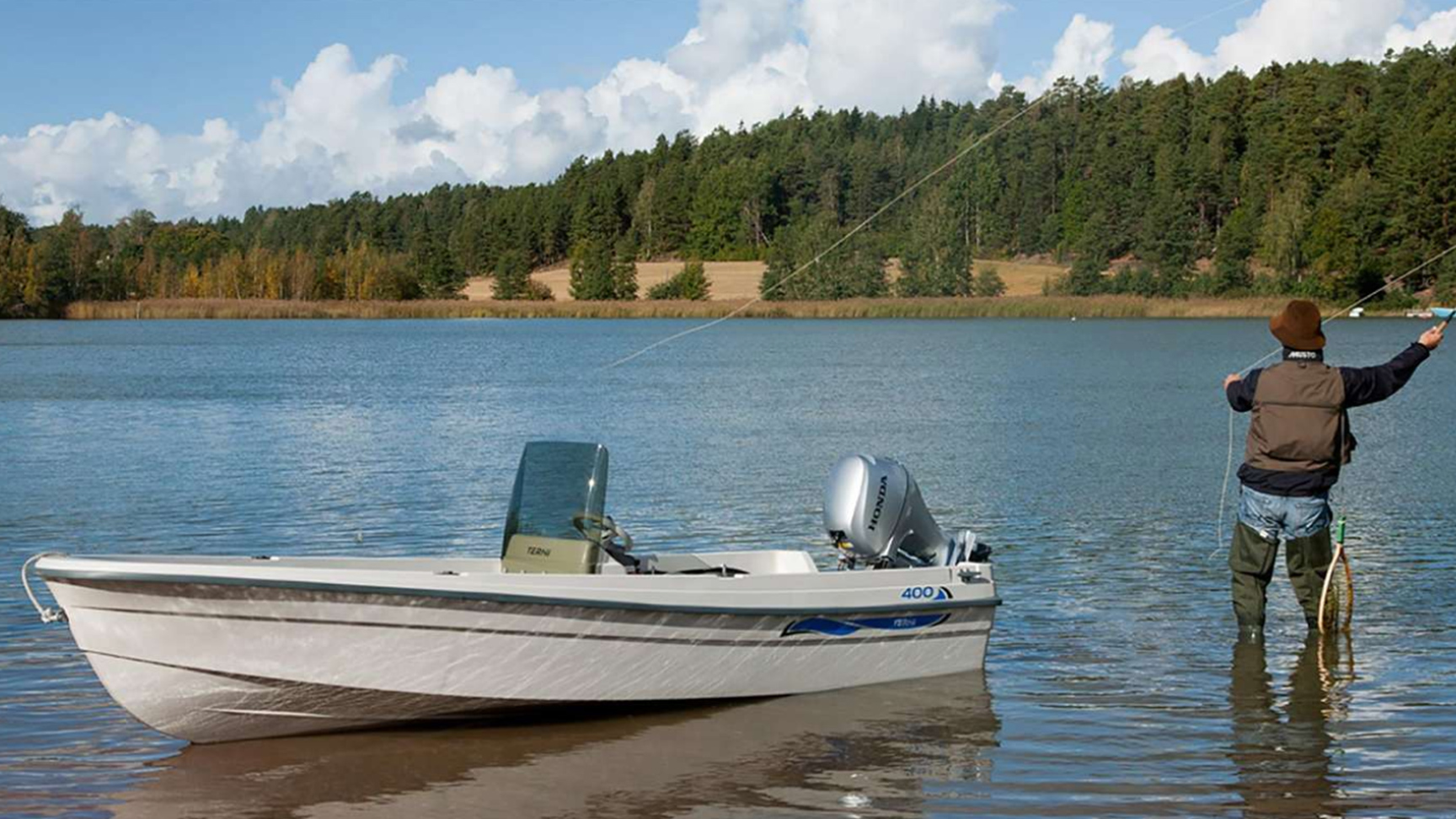 Model vissend in een meer, boot met de BF8-10 motor in de buurt.