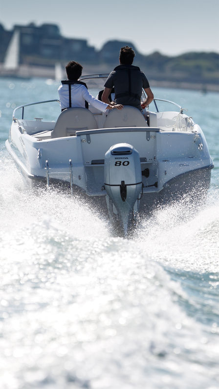 Boot met BF80 motor, in gebruik door modellen, kustlocatie.