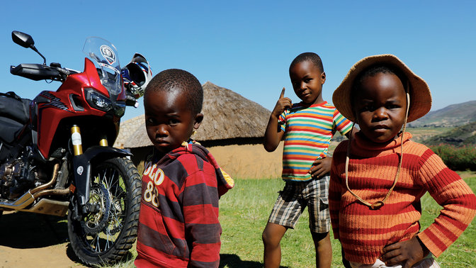 Jonge kinderen buiten verzameld rond een CRF1000L Africa Twin