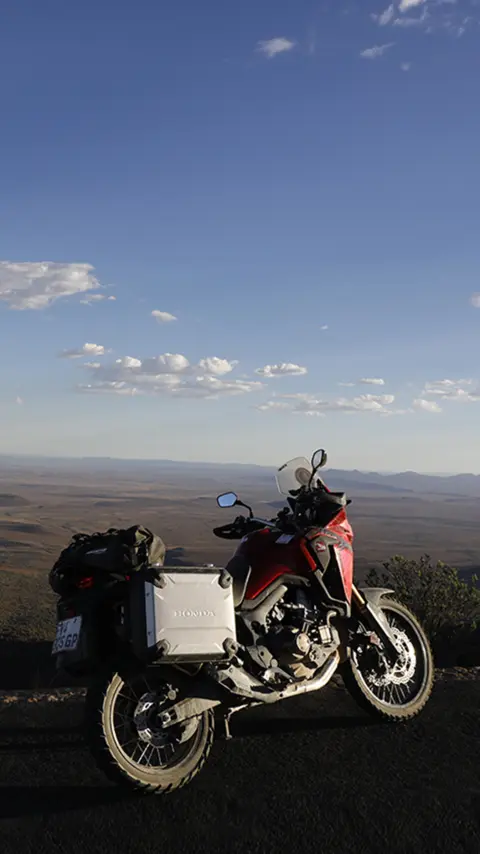 Honda CRF1000L Africa Twin geparkeerd op de weg met uitzicht op de Karoo woestijn.