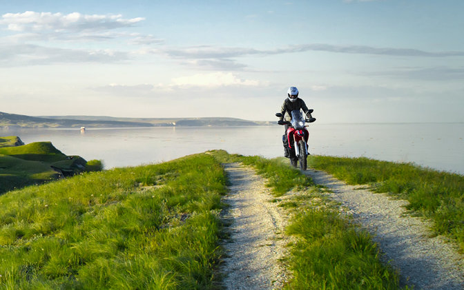 CRF250 Rally met rijder op kustweg