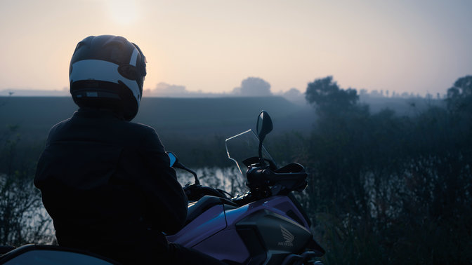 Rijder op een Honda NC750X, geparkeerd op een buitenlocatie.