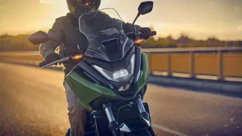 Vooraanzicht model rijdend op de NC750X motorfiets op de baan.