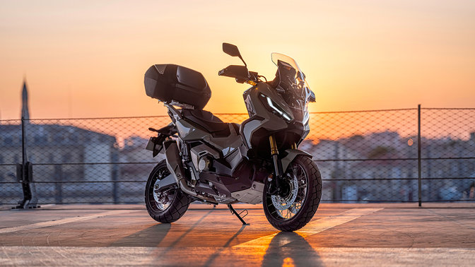 Honda X-ADV driekwartvooraanzicht van rechts, geparkeerd op parking, zonsondergang