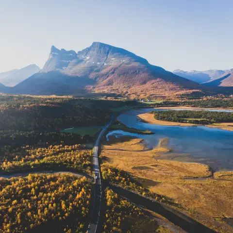 Klassiek Noors-Scandinavisch berglandschap in de zomer met weg, bergen en fjord met een blauwe lucht, Noord-Noorwegen, provincie Finnmark, gefotografeerd vanuit een drone