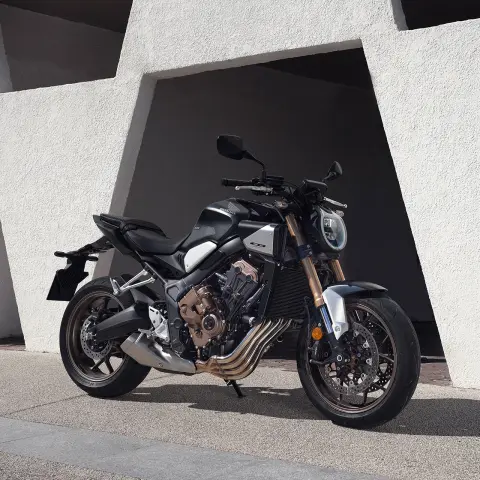 Model rijdend op een motorfiets in een berglandschap.