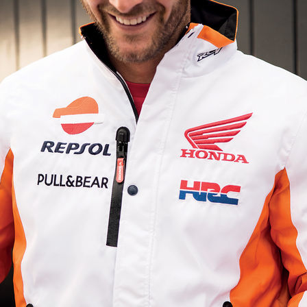 Glimlachende man draagt een Honda race-trui.