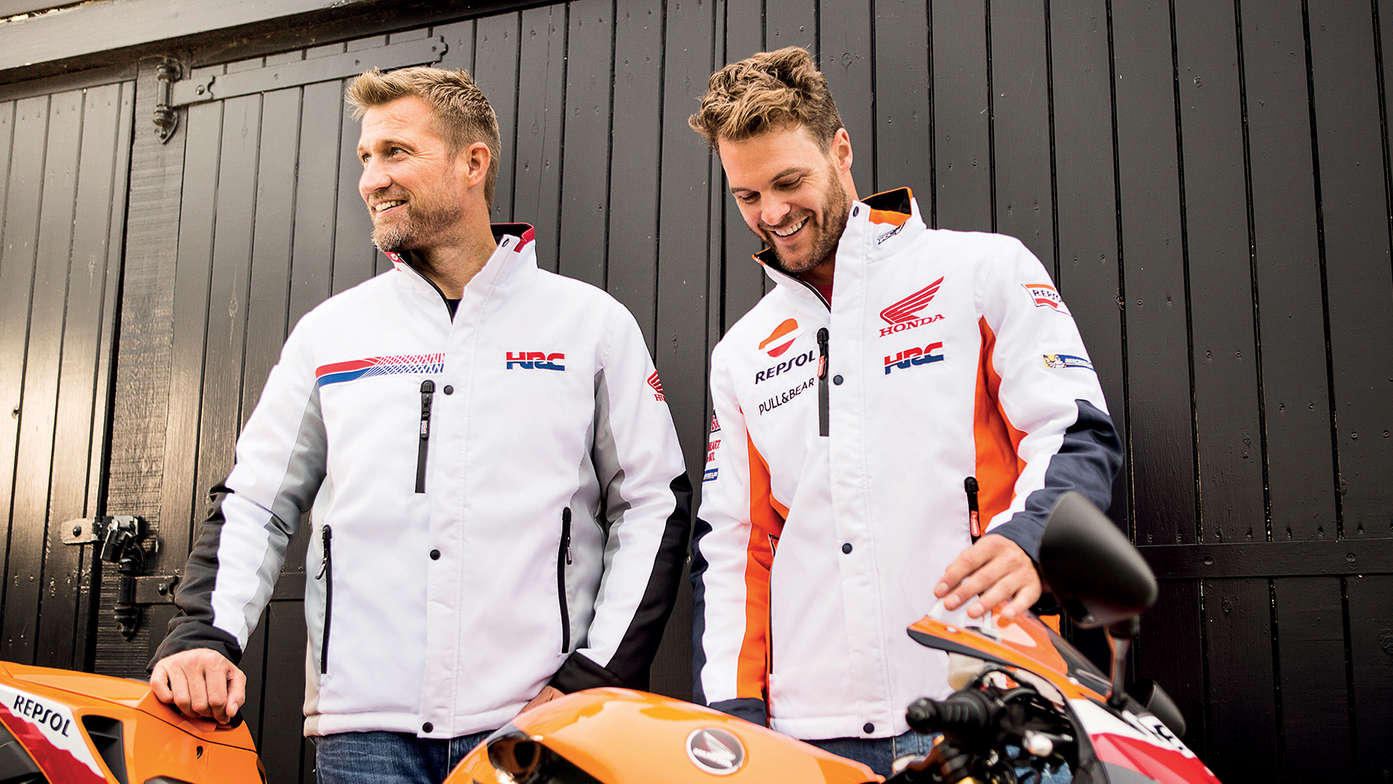 Twee mannen, glimlachend, dragen witte Honda racevesten