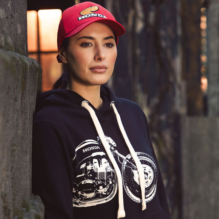 Vrouw in vintage Honda hoodie en pet. 