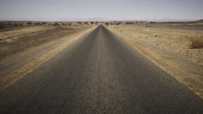 Lange Marokkaanse autosnelweg omgeven door woestijn. 