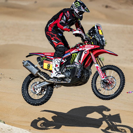 Dakar-rijder van Honda op motorfiets in de woestijn.
