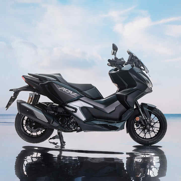 Zijdelings aanzicht van de Honda ADV350 op locatie aan de kust. 