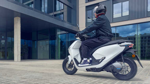 Model rijdend op de Honda CUV e motorfiets demonstreert de gemakkelijke achteruitrijfunctie.