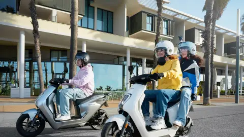 Honda EM1 e: in grijs-witte kleurstelling met rijders op de baan.