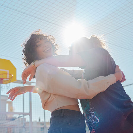Twee modellen knuffelend in het zonlicht op de EM1 e: fotoshoot