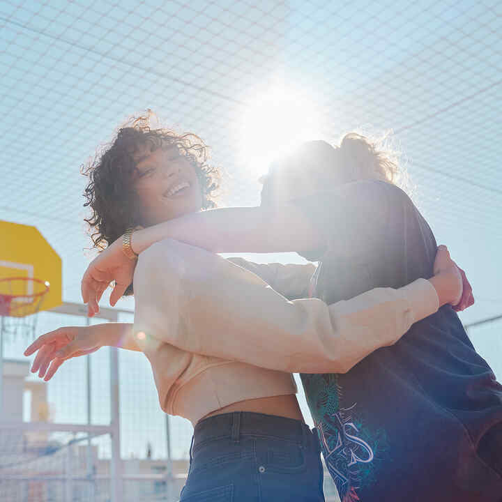 Twee modellen knuffelend in het zonlicht op de EM1 e: fotoshoot