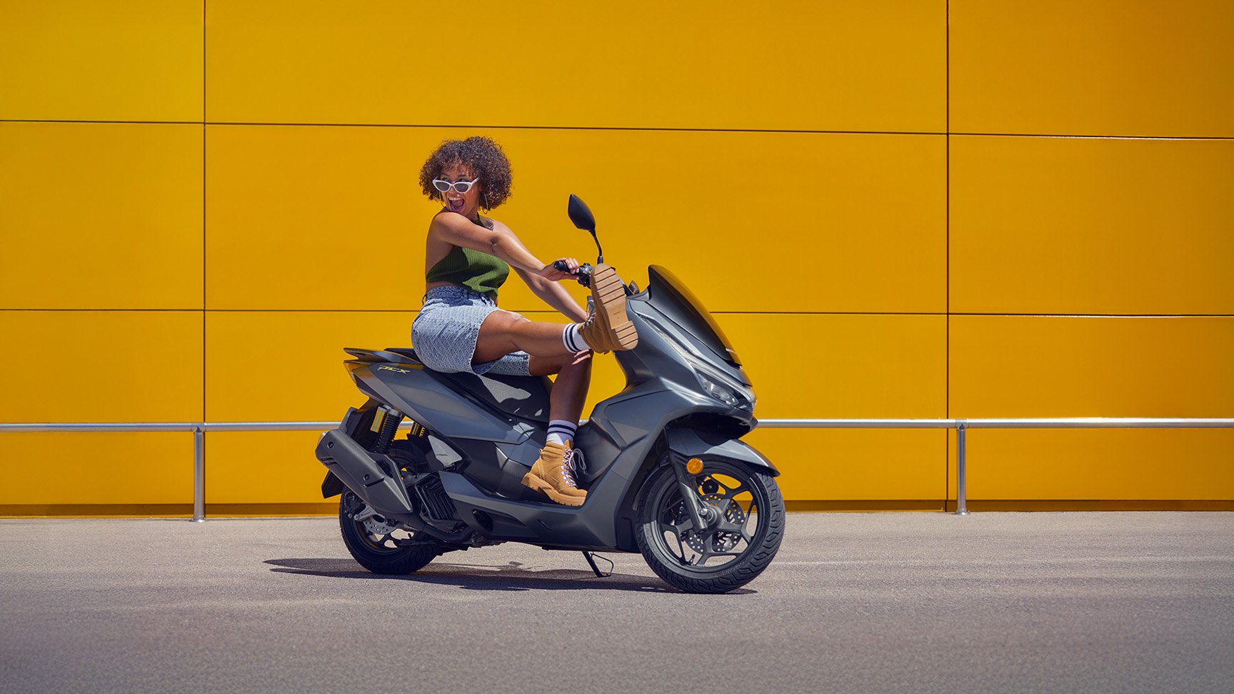 Model zittend op de PCX 125-motorfiets.