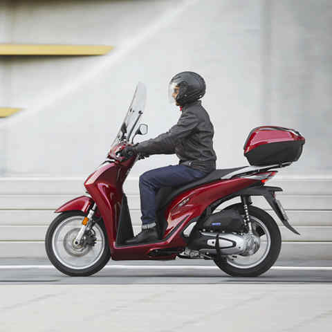 Honda SH150i, linkeraanzicht, met motorrijder, rijdend in de stad
